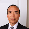 Headshot of a man in a black suit and tie