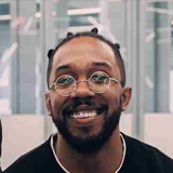 A man smiles while sitting in an office