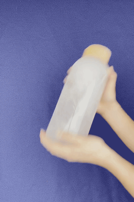 close up of a person drinking a wellness shot with vibrant green liquid, focus on the bottle